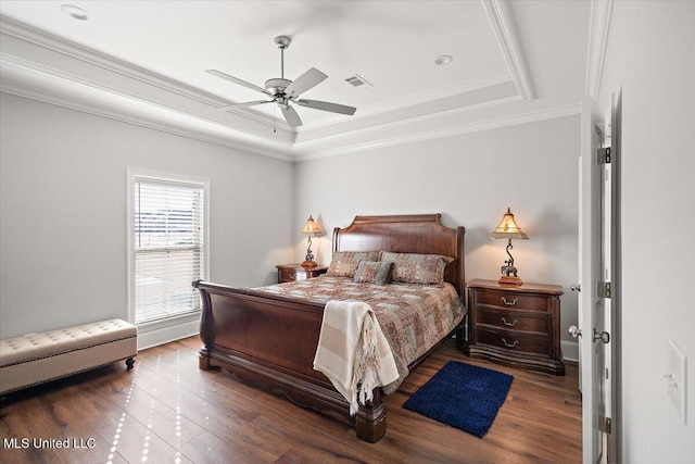 bedroom with hardwood / wood-style flooring, crown molding, ceiling fan, and a tray ceiling