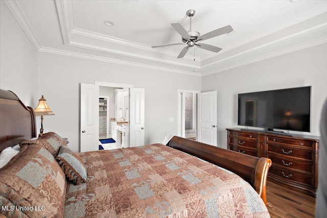 bedroom featuring crown molding, a raised ceiling, and hardwood / wood-style flooring