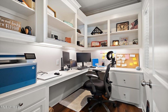 home office featuring dark hardwood / wood-style floors and built in desk