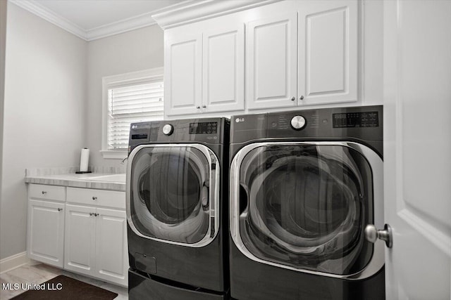 washroom featuring cabinets, ornamental molding, and washing machine and clothes dryer