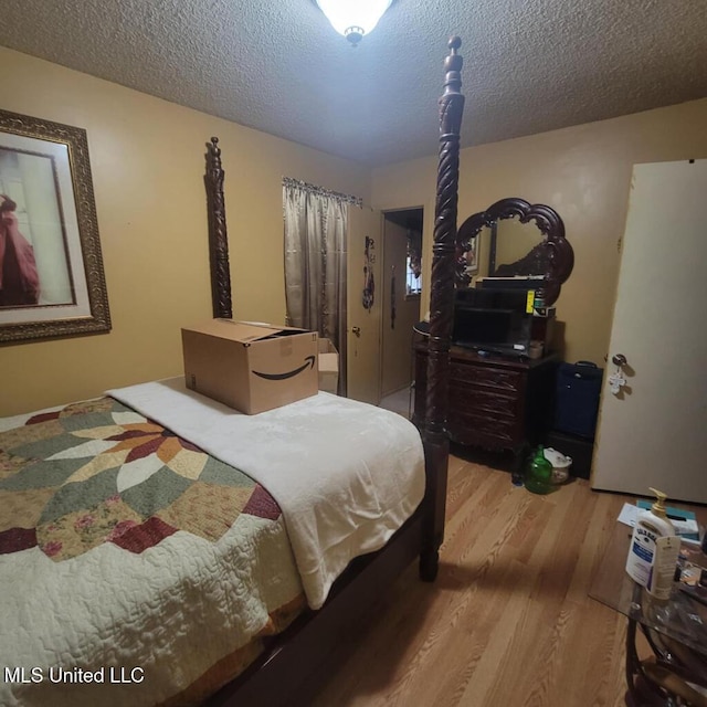 bedroom with a textured ceiling and hardwood / wood-style flooring