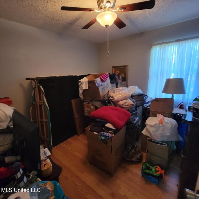 bedroom featuring hardwood / wood-style flooring, ceiling fan, and a textured ceiling