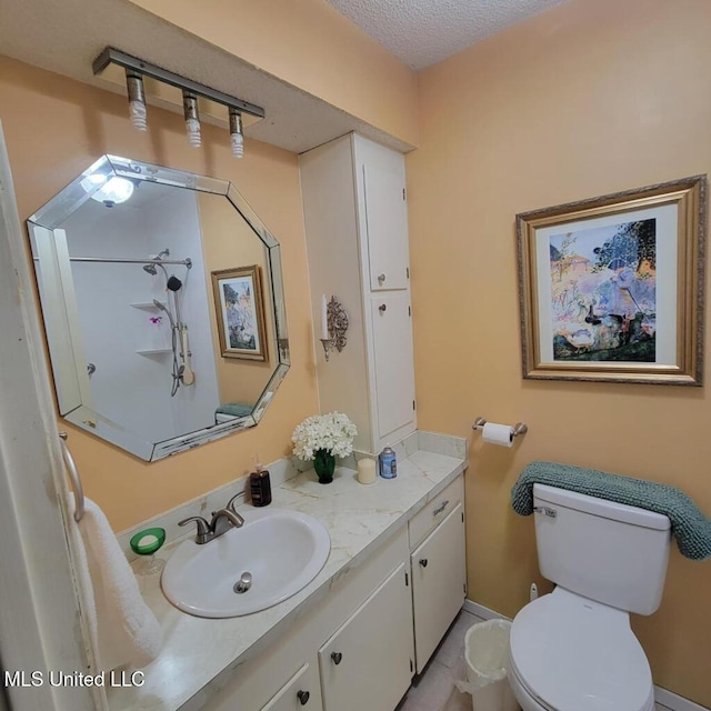 bathroom with a textured ceiling, vanity, and toilet