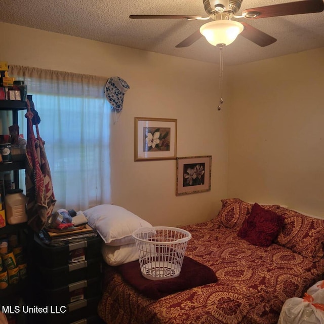 bedroom featuring ceiling fan and a textured ceiling