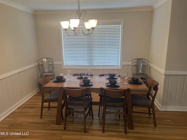 dining space with crown molding, hardwood / wood-style flooring, and a chandelier