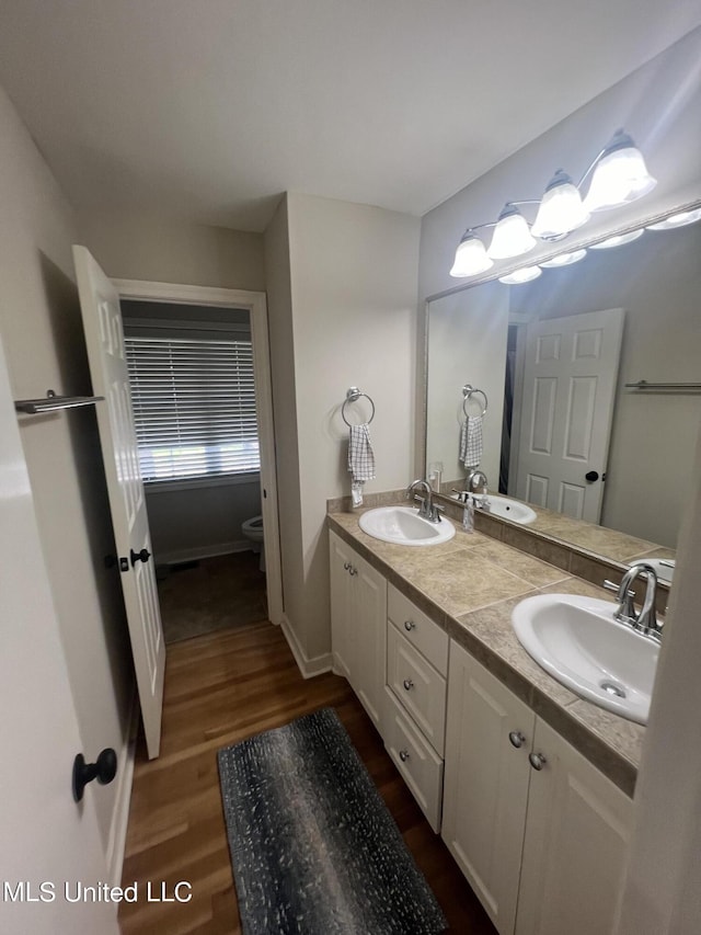 bathroom featuring toilet, hardwood / wood-style flooring, and vanity