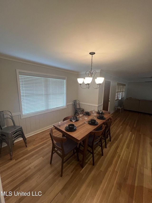 dining area featuring a healthy amount of sunlight, hardwood / wood-style floors, and a chandelier