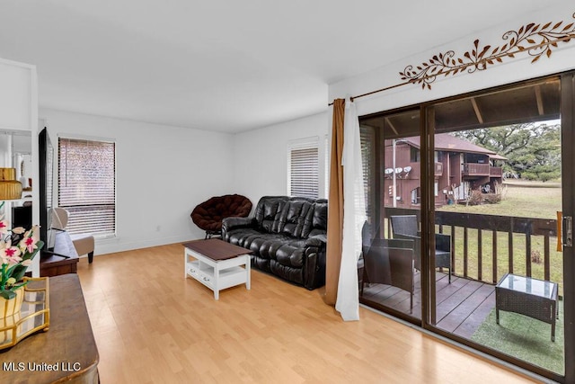 living room with baseboards, plenty of natural light, and light wood-style floors