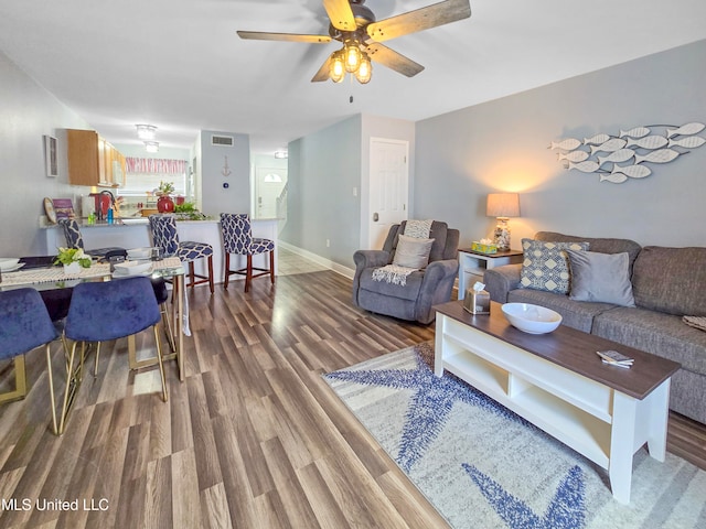 living room with dark wood-type flooring and ceiling fan