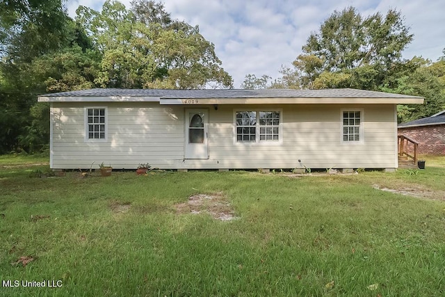 back of property featuring a yard