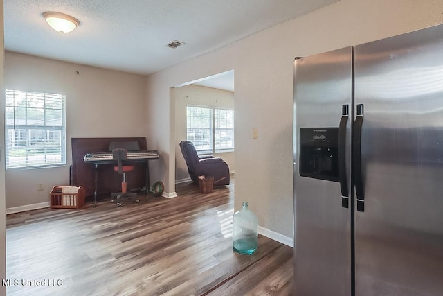 kitchen with stainless steel fridge and hardwood / wood-style flooring