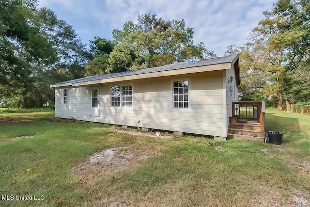 rear view of house featuring a yard