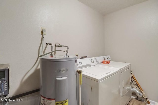 washroom featuring washer and clothes dryer, electric water heater, and a textured ceiling