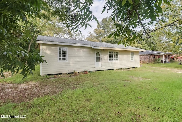 rear view of house featuring a yard