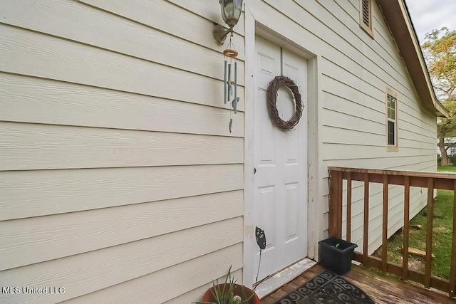 view of exterior entry featuring a wooden deck