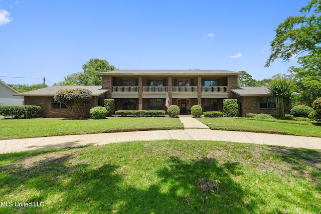 524 Champlin St, Gulfport, MS 39507 - view of front of home with a balcony, a front lawn, and brick siding