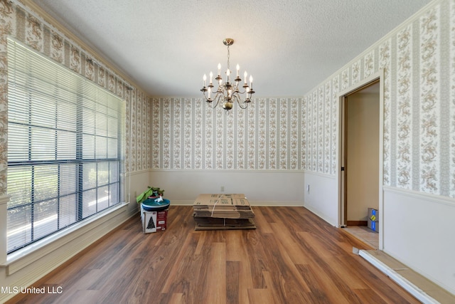 524 Champlin St, Gulfport, MS 39507 - dining space with wainscoting, a chandelier, wallpapered walls, wood finished floors, and a textured ceiling