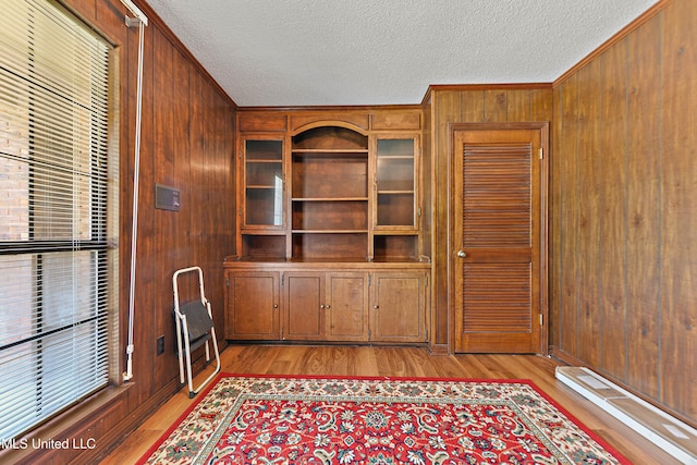 524 Champlin St, Gulfport, MS 39507 - unfurnished office with a textured ceiling, wooden walls, light wood-style flooring, and crown molding