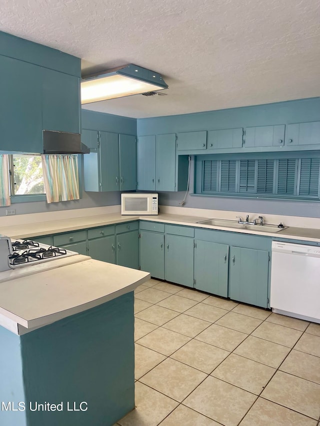 kitchen with sink, a textured ceiling, white appliances, and light tile patterned floors