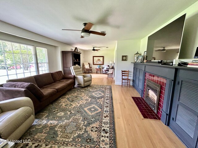 308 College St, Carthage, MS 39051 - living area featuring light wood-type flooring, a ceiling fan, and a fireplace