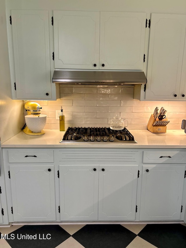 308 College St, Carthage, MS 39051 - kitchen with light countertops, white cabinets, decorative backsplash, and stainless steel gas stovetop