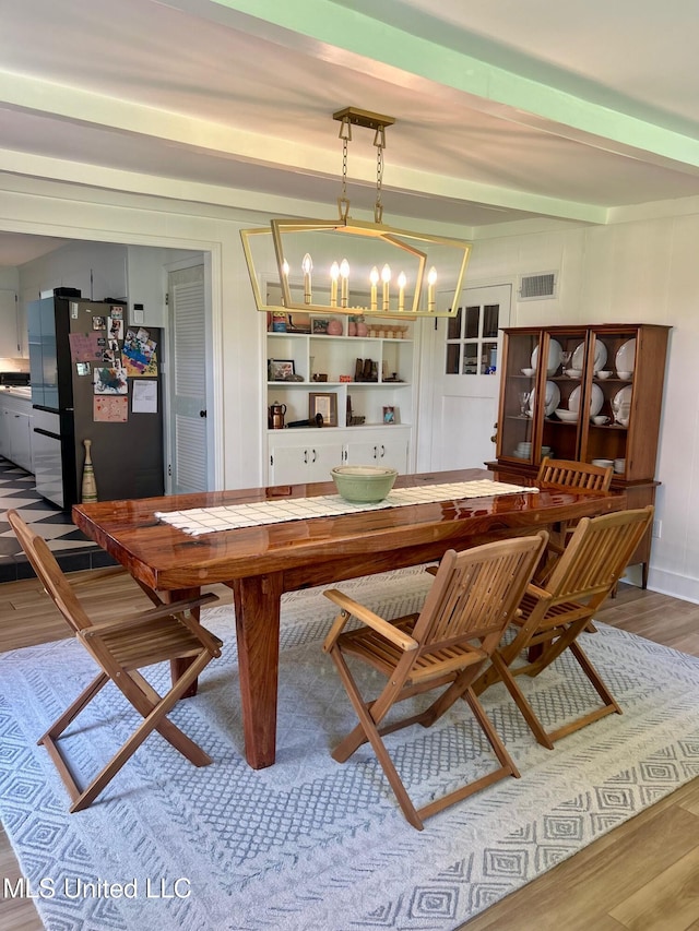 308 College St, Carthage, MS 39051 - dining space featuring visible vents, wood finished floors, and a notable chandelier