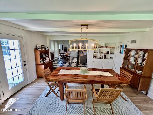 308 College St, Carthage, MS 39051 - dining room with an inviting chandelier, beam ceiling, wood finished floors, and visible vents