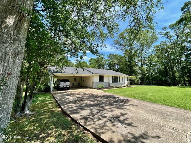 308 College St, Carthage, MS 39051 - single story home with an attached carport, stucco siding, driveway, and a front yard