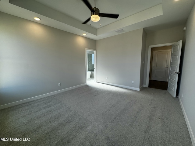 carpeted empty room featuring ceiling fan and a tray ceiling