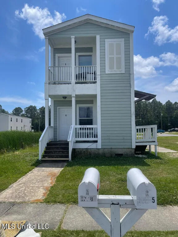 12205 Prudie Cir, Gulfport, MS 39503 - view of front of property featuring a balcony, a porch, and a front yard