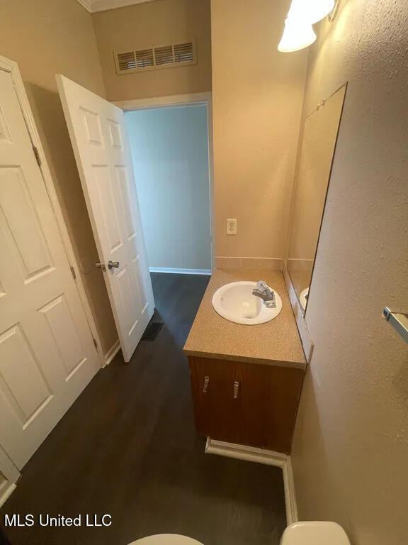 12205 Prudie Cir, Gulfport, MS 39503 - bathroom with vanity, toilet, wood finished floors, and baseboards