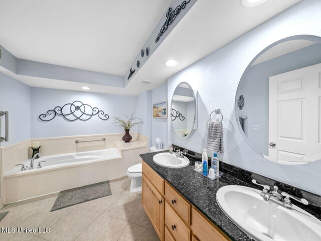 bathroom with vanity, toilet, tile patterned flooring, and a washtub