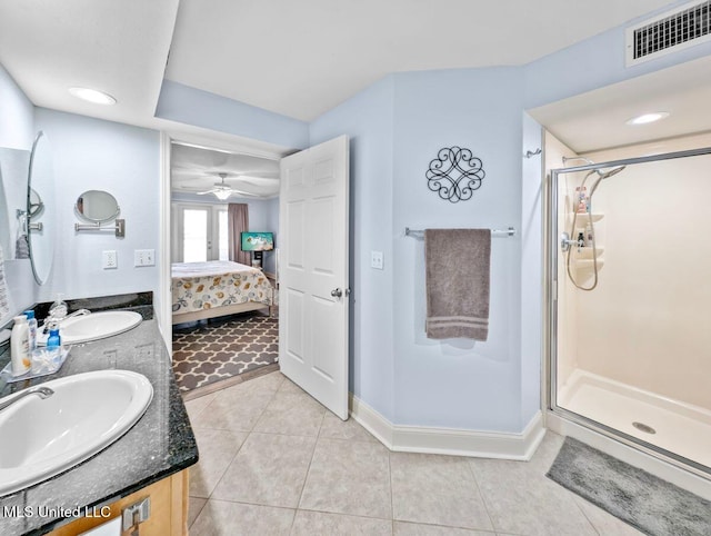 bathroom featuring a shower with door, vanity, and tile patterned floors