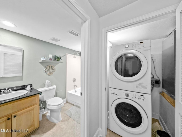 laundry room with stacked washer and dryer, sink, and light tile patterned floors