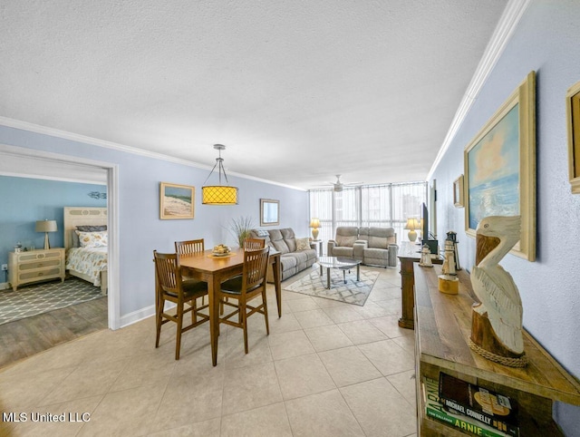 dining space featuring light tile patterned floors, crown molding, and a textured ceiling