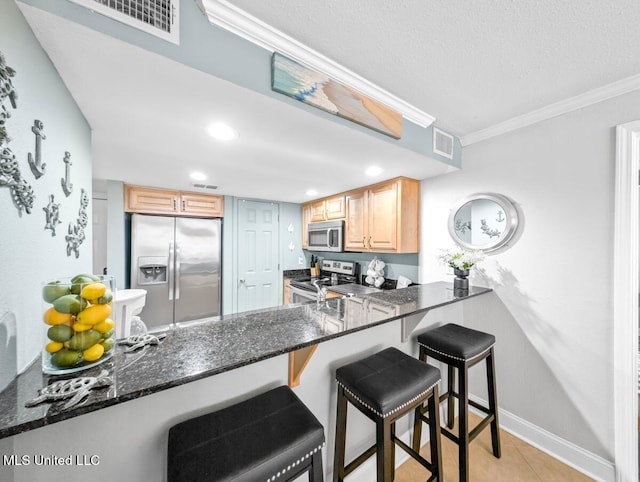 kitchen featuring stainless steel appliances, kitchen peninsula, and light brown cabinets