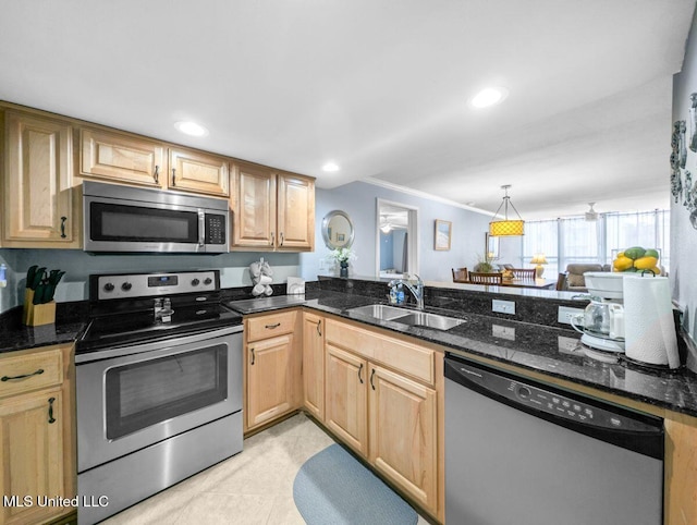 kitchen featuring stainless steel appliances, pendant lighting, sink, and dark stone countertops