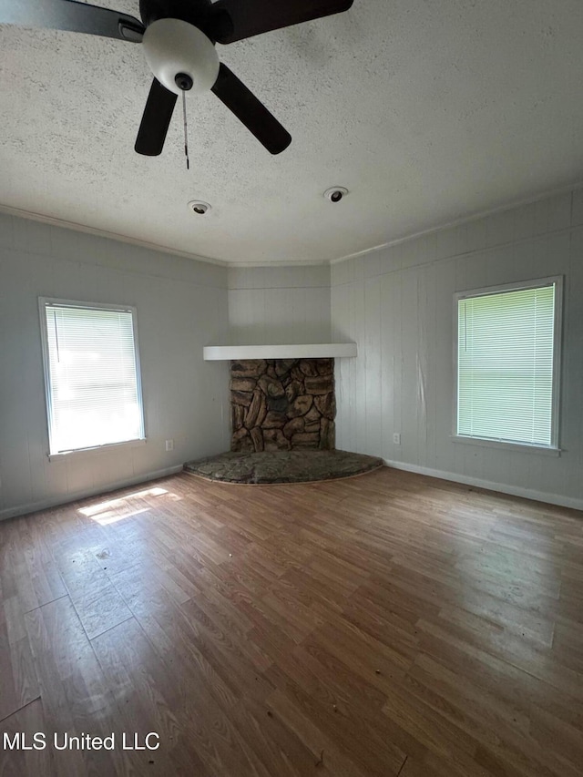 941 Dorgan St, Jackson, MS 39204 - unfurnished living room featuring wood finished floors, a textured ceiling, a fireplace, and ceiling fan