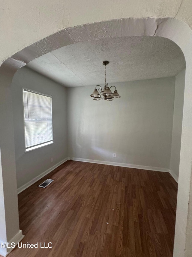 941 Dorgan St, Jackson, MS 39204 - unfurnished room with a chandelier, wood finished floors, arched walkways, and a textured ceiling