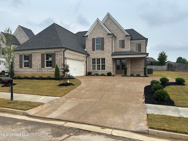 view of front of property with a garage, central air condition unit, and a front lawn