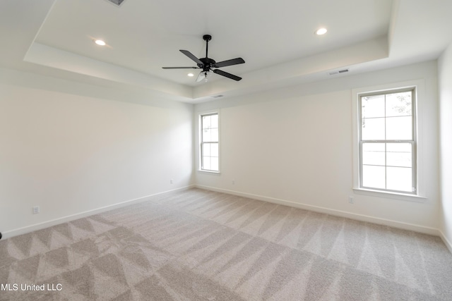 unfurnished room with recessed lighting, a raised ceiling, visible vents, baseboards, and ceiling fan