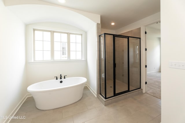 bathroom with baseboards, tile patterned flooring, a shower stall, and a freestanding bath