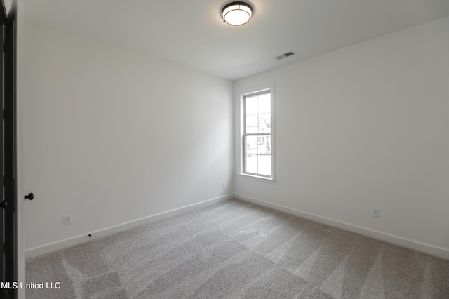 carpeted empty room featuring visible vents and baseboards