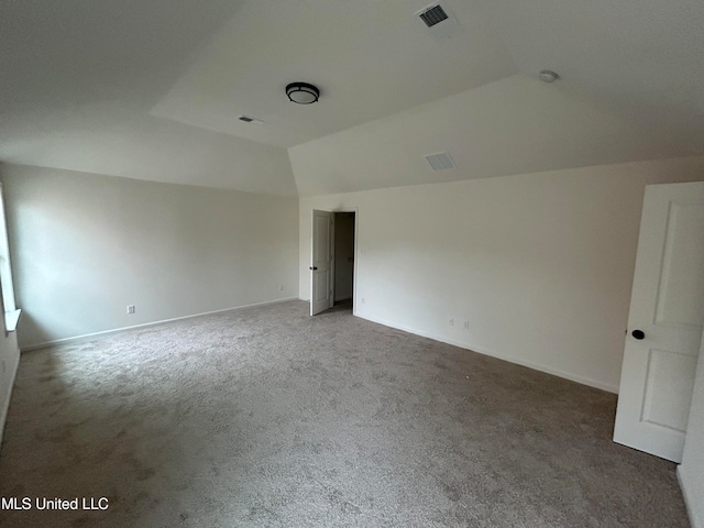 empty room featuring carpet flooring and lofted ceiling