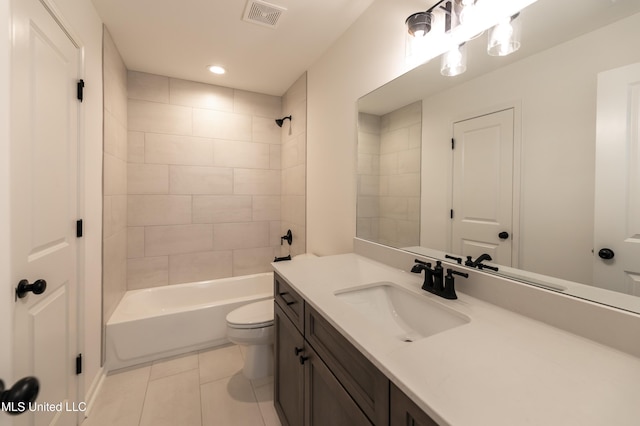 full bathroom with toilet, tile patterned flooring, vanity, and tiled shower / bath