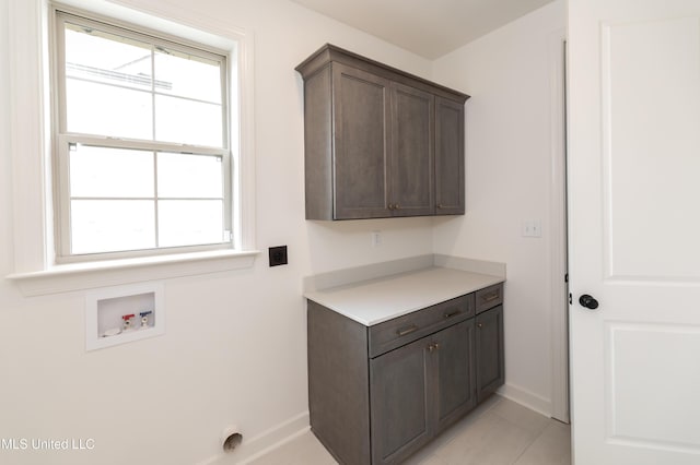 laundry room featuring cabinets, washer hookup, and light tile patterned floors