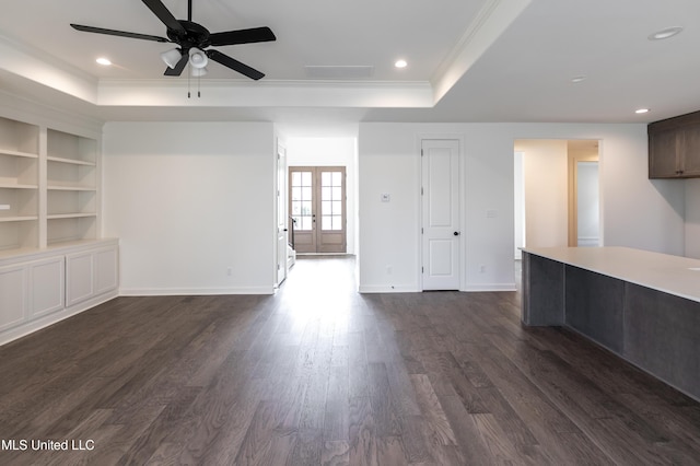 unfurnished living room with recessed lighting, a tray ceiling, a ceiling fan, crown molding, and dark wood-style flooring