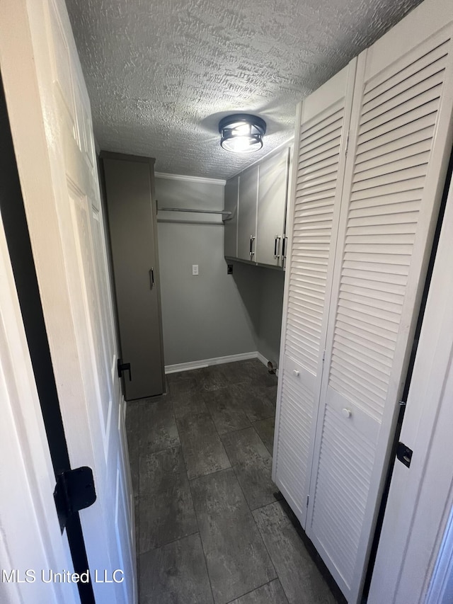 washroom with a textured ceiling and baseboards