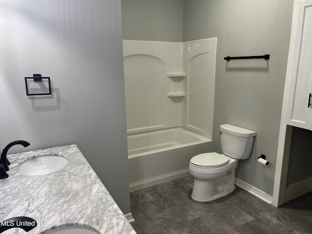 bathroom with washtub / shower combination, vanity, toilet, and baseboards