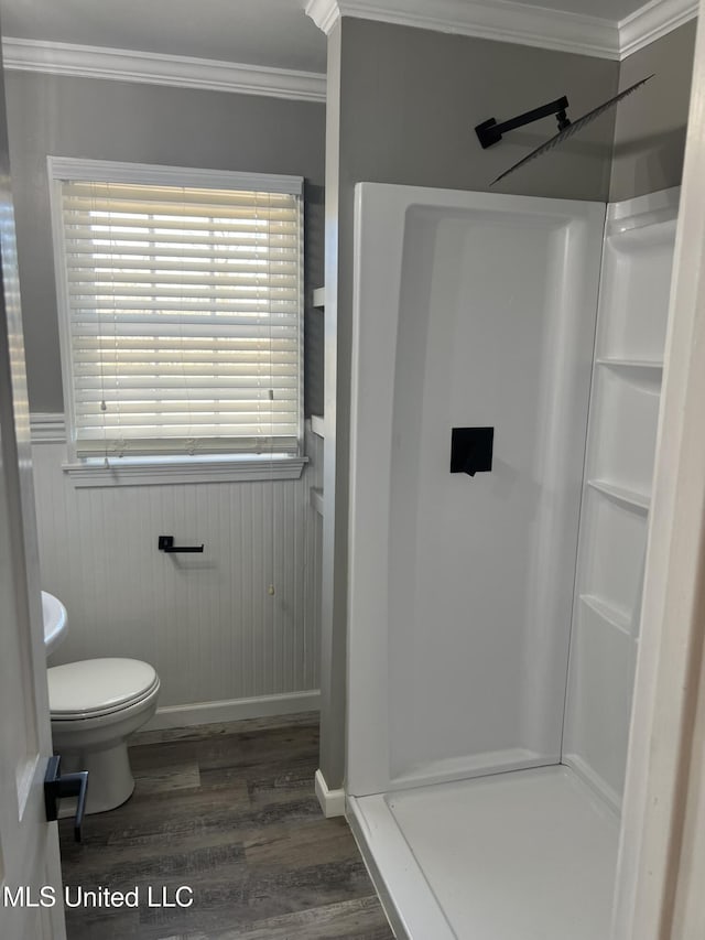 bathroom with a wainscoted wall, crown molding, and a shower stall